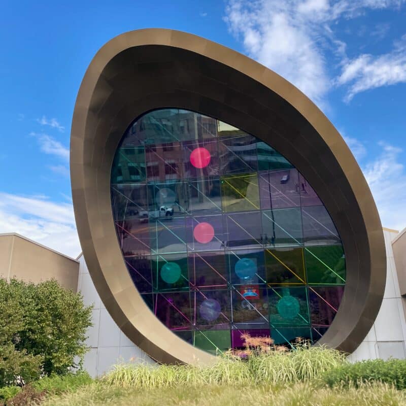 A view of a colorful square and circle glass window at the Strong Museum of Play. The large window is in the shape of an egg