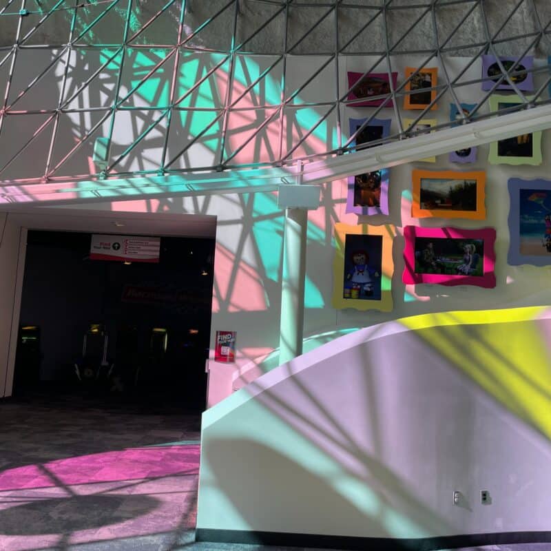 The inside of the Strong Museum of Play with light coming in through colored glass, including trans coloring