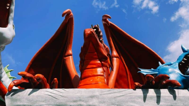 A close-up of the Tiamat statue at the Strong Museum of play, mainly showing the red center dragon head and claws over a pedestal