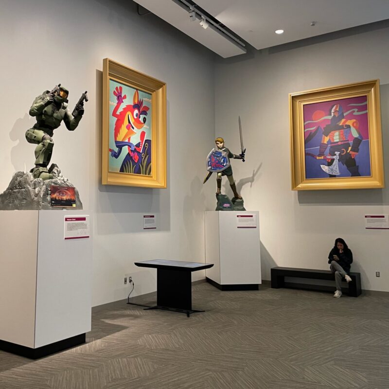 Large cubist paintings of Kratos and Crash Bandicoot, as well as large statues of Master Chief and Link at the Strong Museum of Play