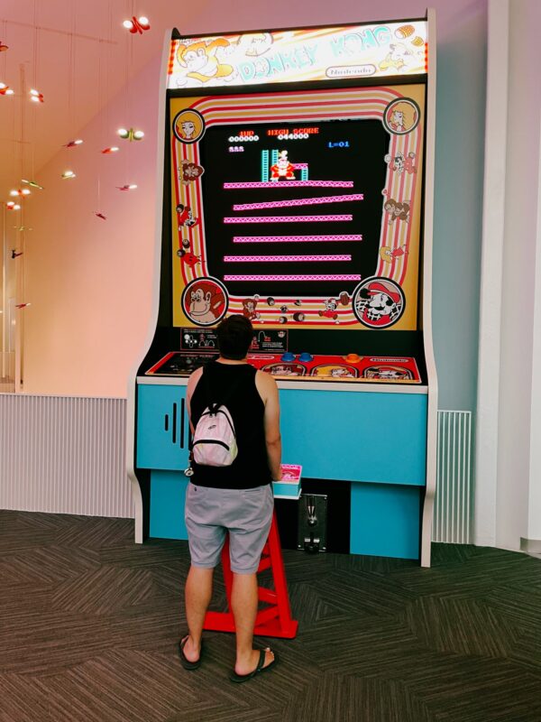 A person playing an oversized arcade game of Donkey Kong at the Strong Museum of Play