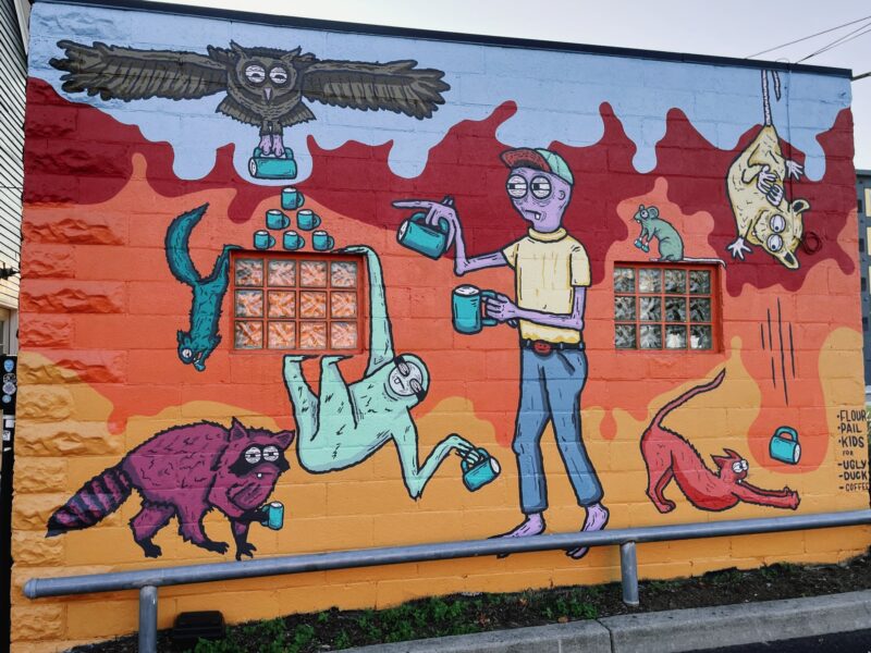 a mural of a person and various animals getting coffee at Ugly Duck Coffee in Rochester, NY