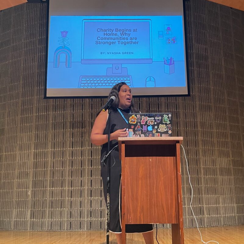 Nyasha Green giving a keynote at WordCamp Rochester, with the title, "Charity Begins at Home, Why Communities are Stronger Together"