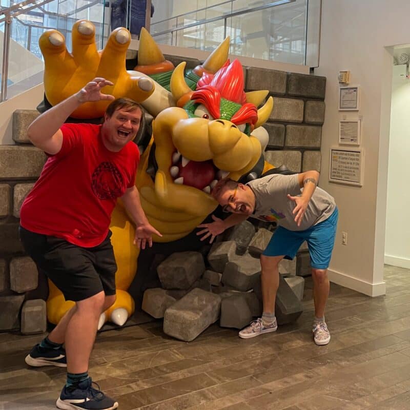 david and Timothy posing in front of a Bowser statue in the Nintendo World Store in NYC