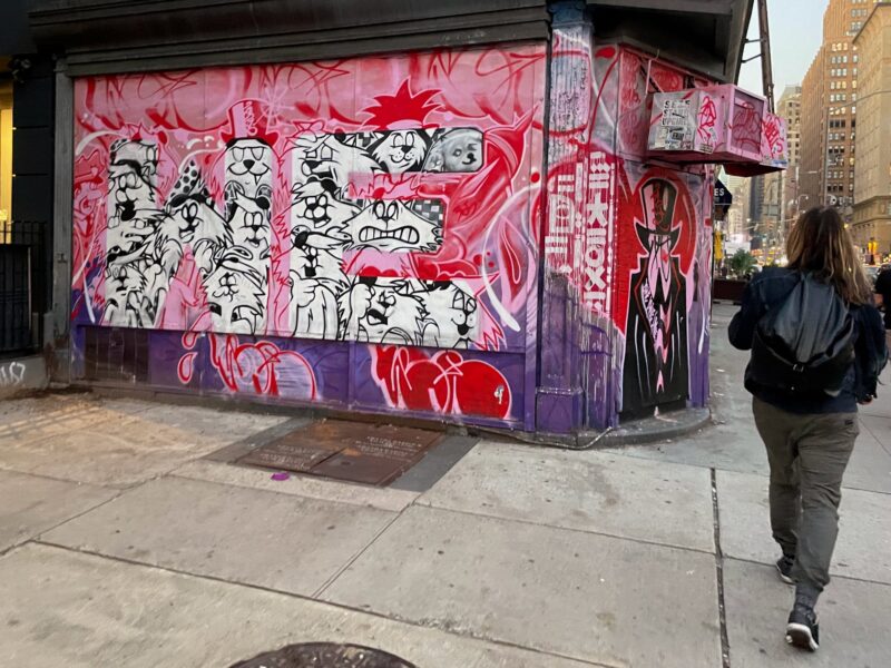 A piece of street art on a wall that shows mainly cat characters and one doge in NYC