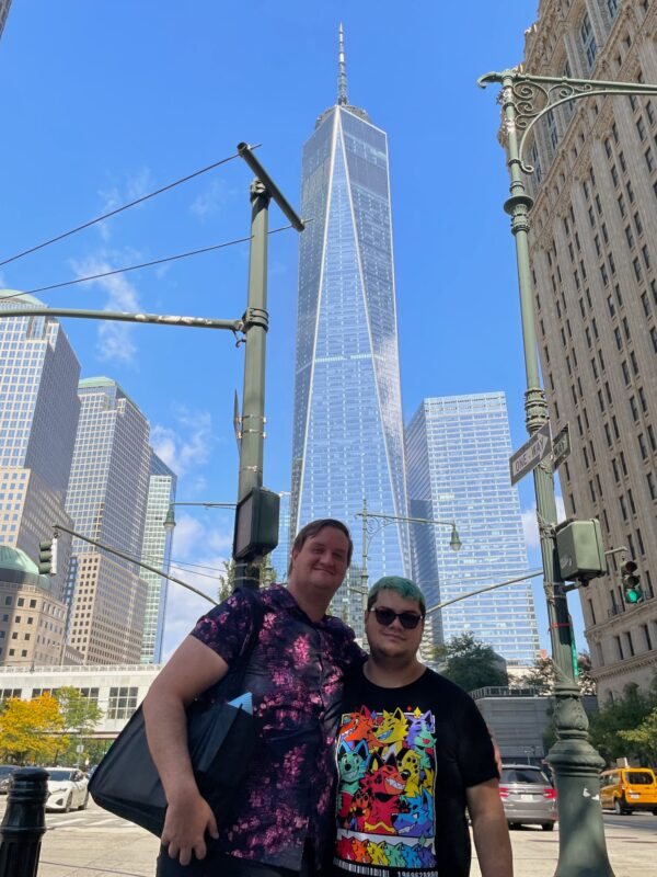 Timothy and Sebastian posing for the camera with One World Trade Center in the background