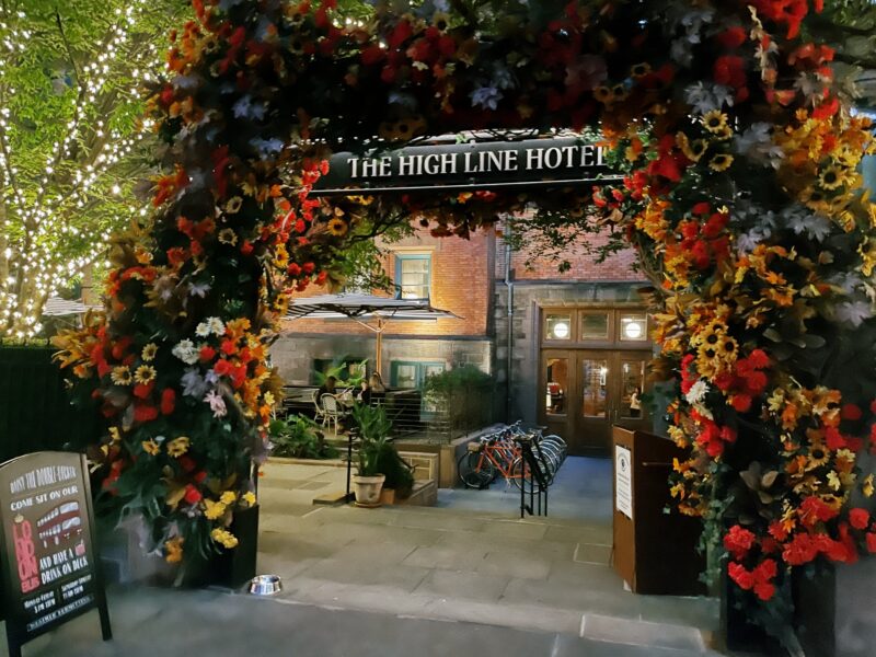 The entrance to The High Line Hotel with hundreds of flowers surrounding the arched entryway