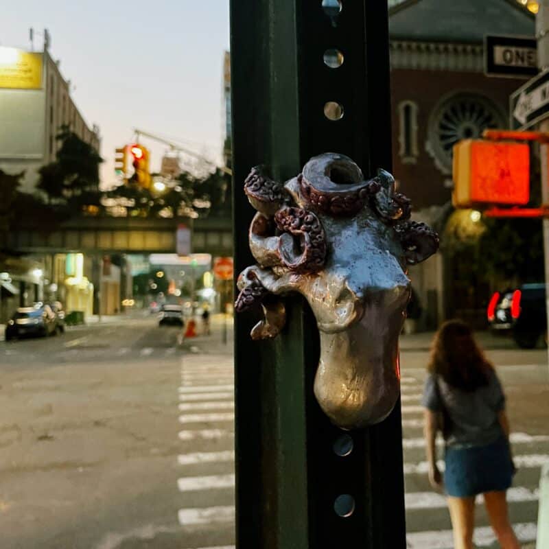 A small sculpture of an octopus holding onto a stop sign post in NYC