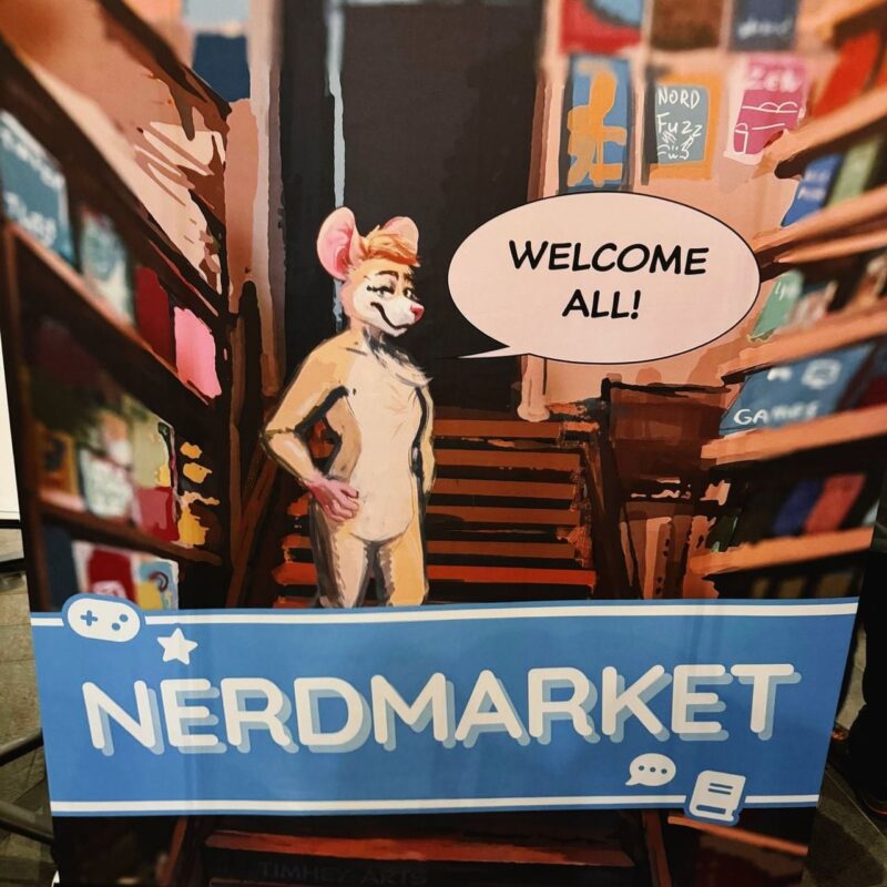 An illustrated poster of a character resembling a furry animal standing on stairs between shelves filled with colorful items. A speech bubble above the character reads Welcome All! Below, a blue banner with a game controller icon and text bubbles reads NERDMARKET. The scene appears welcoming and playful, with vibrant colors.
