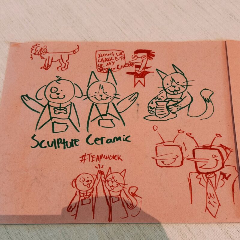 A hand-drawn cartoon on pink paper shows various sketches. In the center, a dog and a cat wear aprons with the words Sculpture Ceramic beneath. Next to them is a cat holding pottery. Above, a person with a speech bubble saying Now's ur chance to see my swag cock. Top left, a small dood