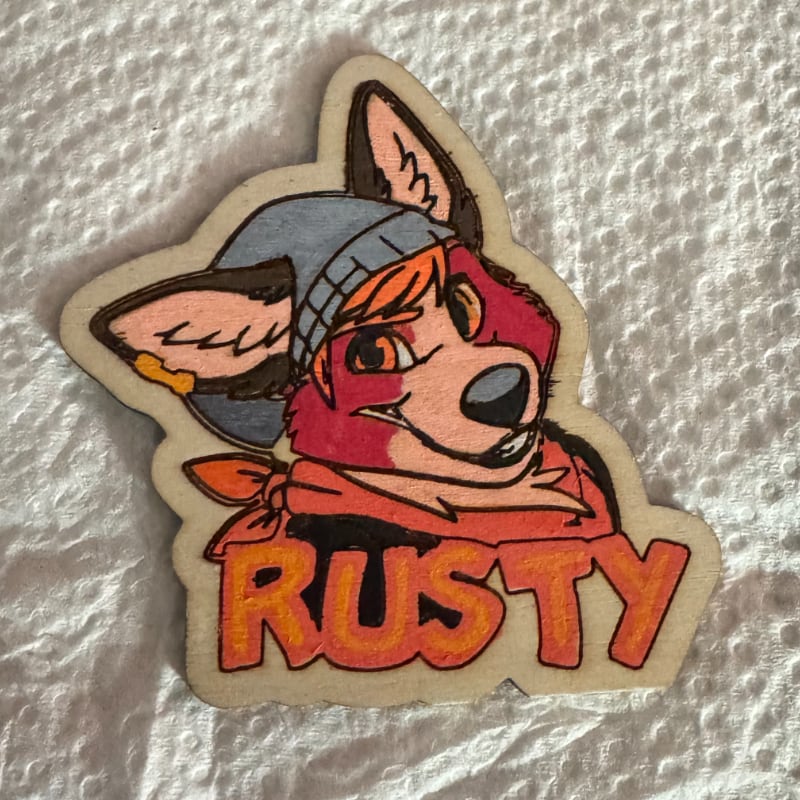 A painted wooden pin of Rusty Corgi